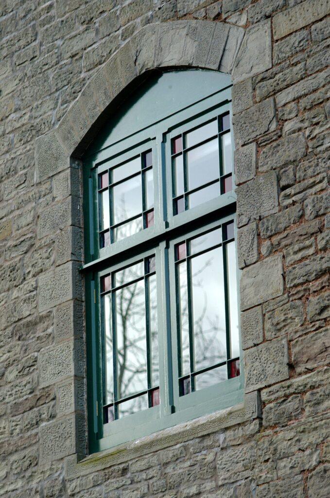 Single glazed casement window with ruby red and cobalt blue glasses to the corner detail in this refined margin lights design